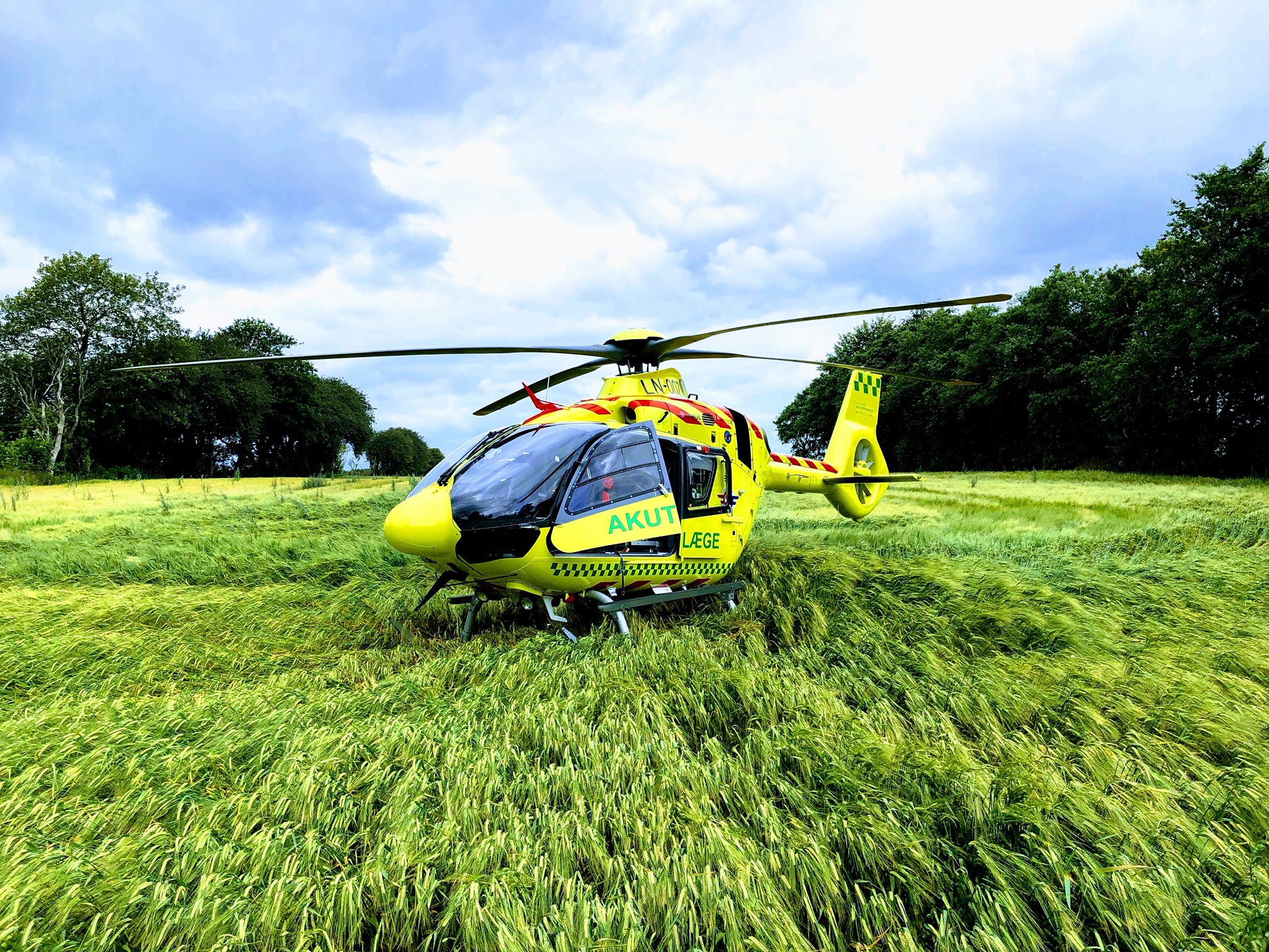Akutlægehelikopter på mark.jpg